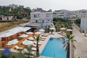 basen z leżakami i parasolami w obiekcie Blue Water Hotel Ksamil w mieście Ksamil