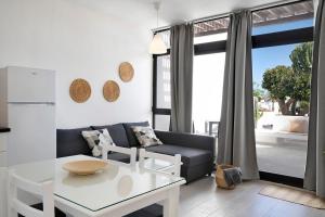 ein Wohnzimmer mit einem Sofa und einem Tisch in der Unterkunft Calimar Los Molinos in Costa Teguise