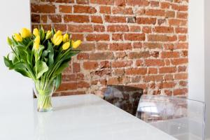 eine Vase gelber Blumen auf einem Tisch in der Unterkunft Apartament Rynek in Breslau