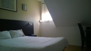 Postel nebo postele na pokoji v ubytování Hôtel d'Alsace