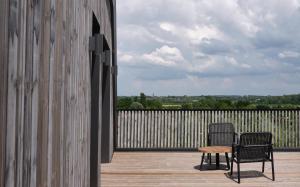 2 Stühle und ein Tisch auf einer Holzterrasse in der Unterkunft BERCAIL in Wambrechies