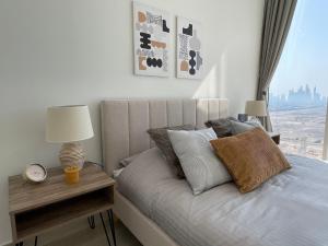 a bedroom with a bed with a clock and a window at Brand New Top Skyline View Apartment in Dubai