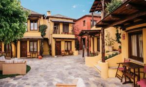 a courtyard of a building with chairs and tables at Alkifron Hotel in Kala Nera
