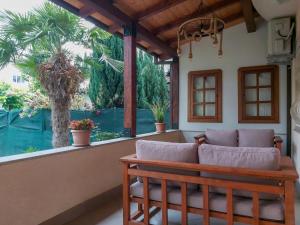 a porch with a bench and a large window at Celus Apartments Ohrid in Ohrid