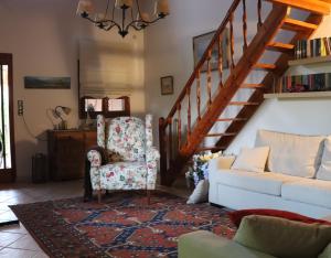 a living room with a chair and a staircase at Kato Posidonia Sounio. The house with lemon trees in Lavrio