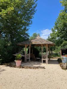 a wooden gazebo with a bench and a table at Chambre pranayama in Montcléra