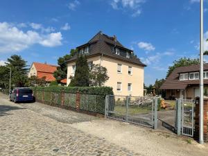 a house with a fence in front of it at Freundliche Zweiraumwohnung in ruhiger Lage in Cottbus