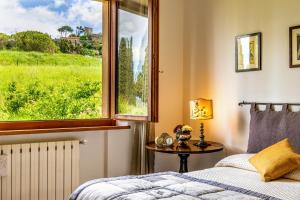 a bedroom with a window and a bed and a table at Villa PoliFlora in Monticchiello