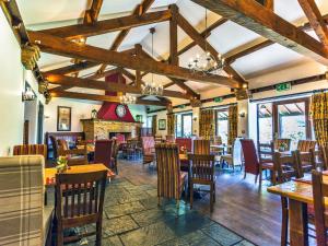 a restaurant with wooden tables and chairs and a fireplace at Holly Hill Inn in Richmond