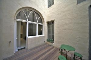 un patio con 2 taburetes verdes y una ventana en Le Nuage - Studio design à Triangle d'Or, en Burdeos