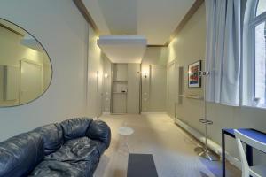sala de estar con sofá de cuero y espejo en Le Nuage - Studio design à Triangle d'Or, en Burdeos