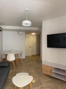 sala de estar con mesa y TV en la pared en Apartamento Aguamarina, en Almerimar