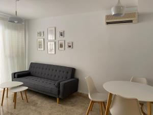 uma sala de estar com um sofá, uma mesa e cadeiras em Apartamento Aguamarina em Almerimar