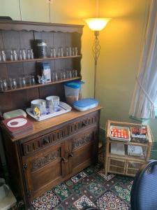 a room with a wooden cabinet with dishes on it at roosevelt lodge in Skegness