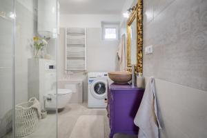 uma casa de banho com um lavatório e uma máquina de lavar roupa em Katica Szállás em Balatonkenese
