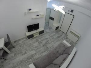 a living room with a couch and a tv at 911 Cazare Mamaia in Mamaia