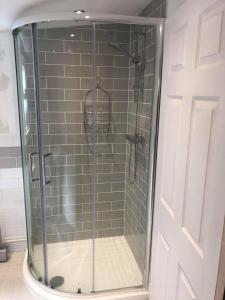 a shower with a glass door in a bathroom at Hideaway at Botany Bay in Broadstairs