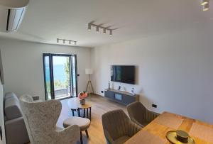 a living room with a table and chairs and a television at Villa Gloria in Cavtat