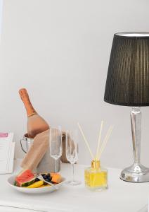 a table with a lamp and a plate of food and glasses at Relais Villa Isabel in Pietrasanta