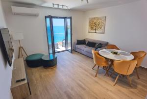 a living room with a table and chairs and a couch at Villa Gloria in Cavtat