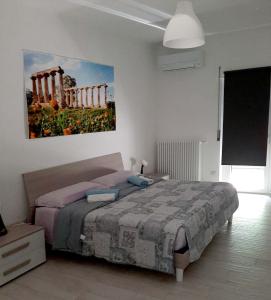 a bedroom with a bed and a painting on the wall at B&b Casa Vita COMFORT HOME in Marconia