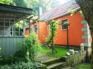 una casa naranja con un camino que conduce a ella en Ferienhaus Franz - an der Elbe, mit großem Garten, en Pirna
