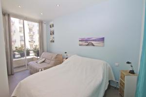 a bedroom with a bed and a chair and a window at Florida Sea Front in Nice