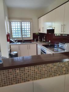 a kitchen with white cabinets and a brown counter top at Melanta Villa in Pissouri