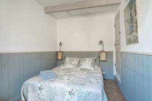 a bedroom with a bed with a blue wall at Maison de village au coeur de l'Isle-sur-la-Sorgue in L'Isle-sur-la-Sorgue