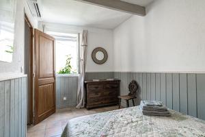 a bedroom with a bed and a dresser and a window at Maison de village au coeur de l'Isle-sur-la-Sorgue in L'Isle-sur-la-Sorgue
