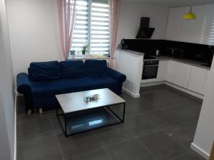 ein Wohnzimmer mit einem blauen Sofa und einem Tisch in der Unterkunft Apartament Giżycko blisko centrum in Giżycko