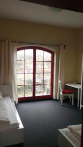 a room with two beds and a large window at Kulturgasthof Alte Reederei in Fürstenberg-Havel