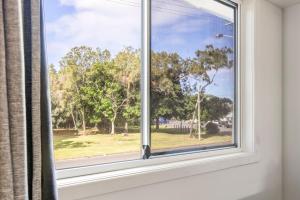 a window with a view of a park at Surf Beach Motel Coffs in Coffs Harbour