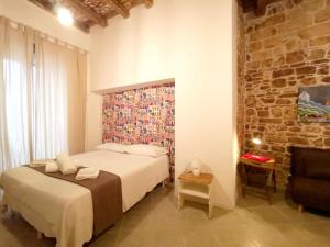 Appartamento Santa Manna, Bari Vecchia في باري: غرفة نوم بسرير وجدار من الطوب