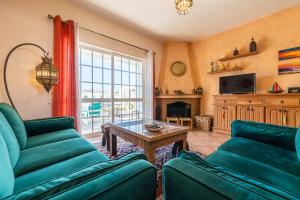 ein Wohnzimmer mit 2 grünen Sofas und einem Tisch in der Unterkunft Villa Galé Sun - Luxury, 5bed with free wifi, AC, private pool, 5 min from the beach in Guia