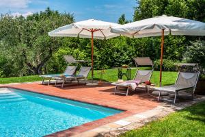 een groep stoelen en parasols naast een zwembad bij Appartamento Piero in Bagno a Ripoli