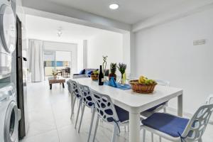 アヤナパにあるMyHome DeLux, Ayia Napa 3 Bedroom with Poolの白いテーブルと椅子のあるキッチンとダイニングルーム
