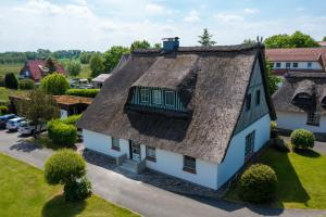 een uitzicht op een huis met een rieten dak bij An der Steilküste Wohnung 01 in Boltenhagen