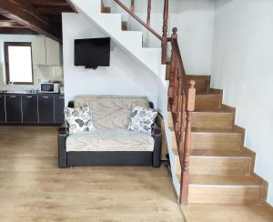 a living room with a couch under a staircase at Cabana 84 in Beclean