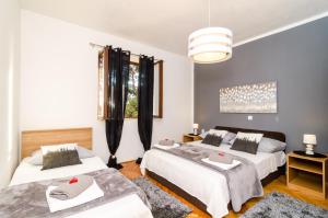 a bedroom with two beds and a window at Apartment Eulalija in Dubrovnik