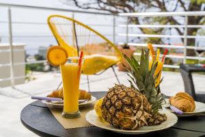 a table with a pineapple and a glass of orange juice at Apartment Eulalija in Dubrovnik