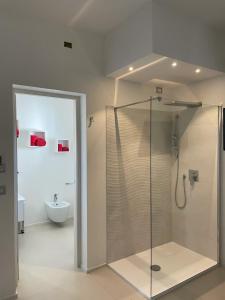 a bathroom with a glass shower and a toilet at Gassa d amante Affittacamere in Stintino