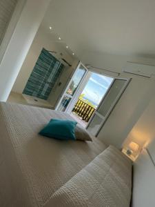 a bedroom with a large bed and a large window at Gassa d amante in Stintino