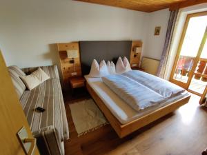 - une chambre avec un grand lit et un canapé dans l'établissement Schlossberg, à San Leonardo in Passiria