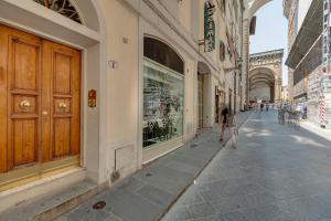 uma mulher a andar numa rua ao lado de um edifício em Mamo Florence - Sophia Apartment em Florença
