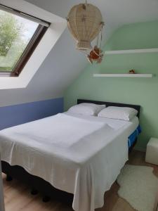 Schlafzimmer mit einem Bett mit weißer Bettwäsche und einem Fenster in der Unterkunft Les prussiens in Wavre