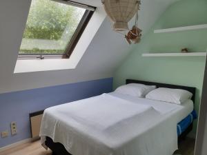 1 dormitorio con 1 cama blanca y ventana en Les prussiens, en Wavre