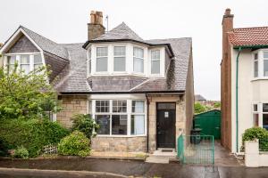 a house with a gray roof and a black door at Rossmore - 5 mins from St Andrews town centre in Fife