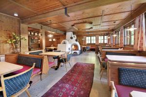 a restaurant with tables and chairs and a fireplace at Alpenchalet Lacknerbrunn bis 30 P in Mayrhofen