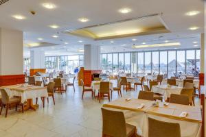 um restaurante com mesas e cadeiras brancas e janelas em DIAMOND OF BODRUM em Bodrum City